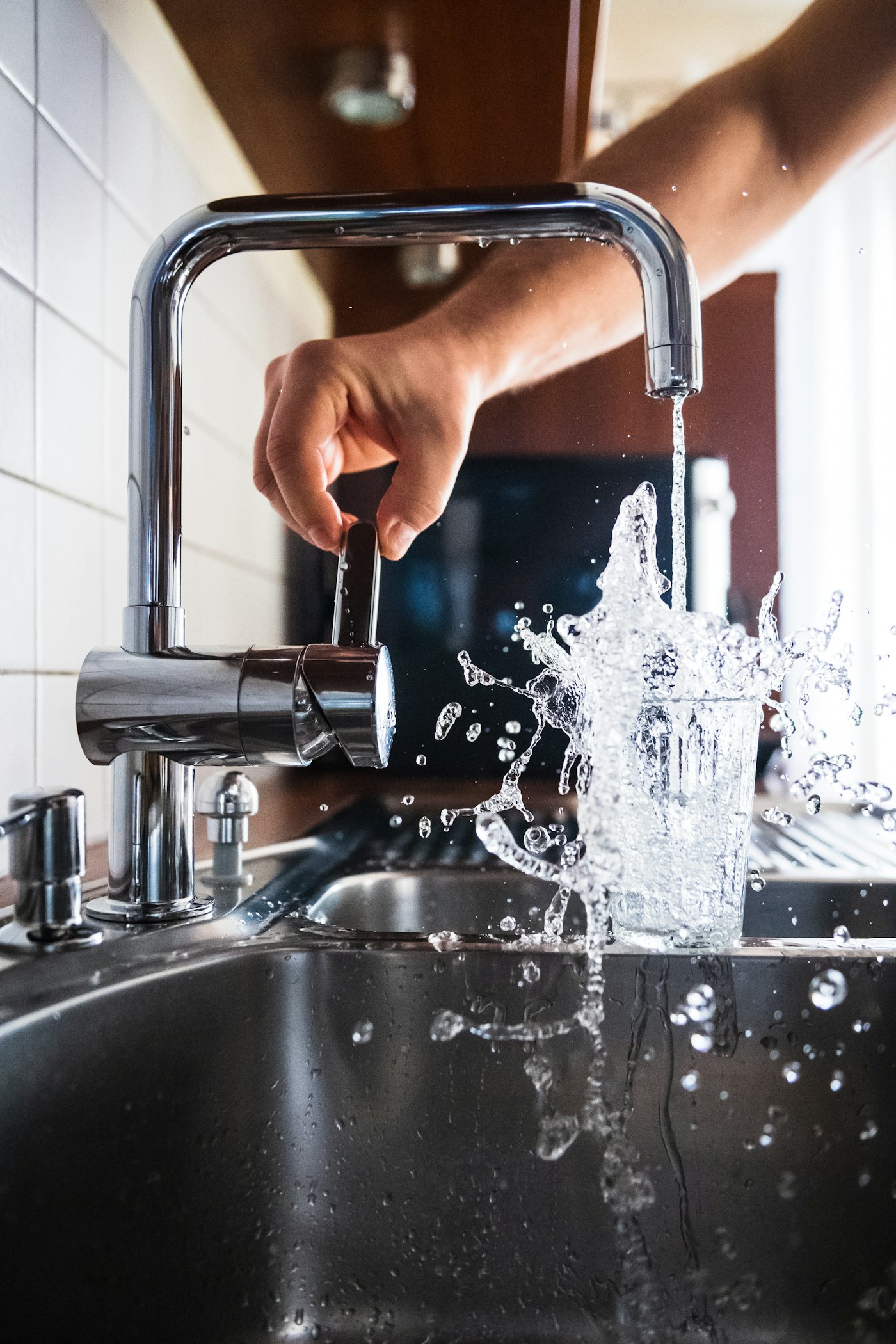 Water bursting from a kitchen faucet, plumbing emergency