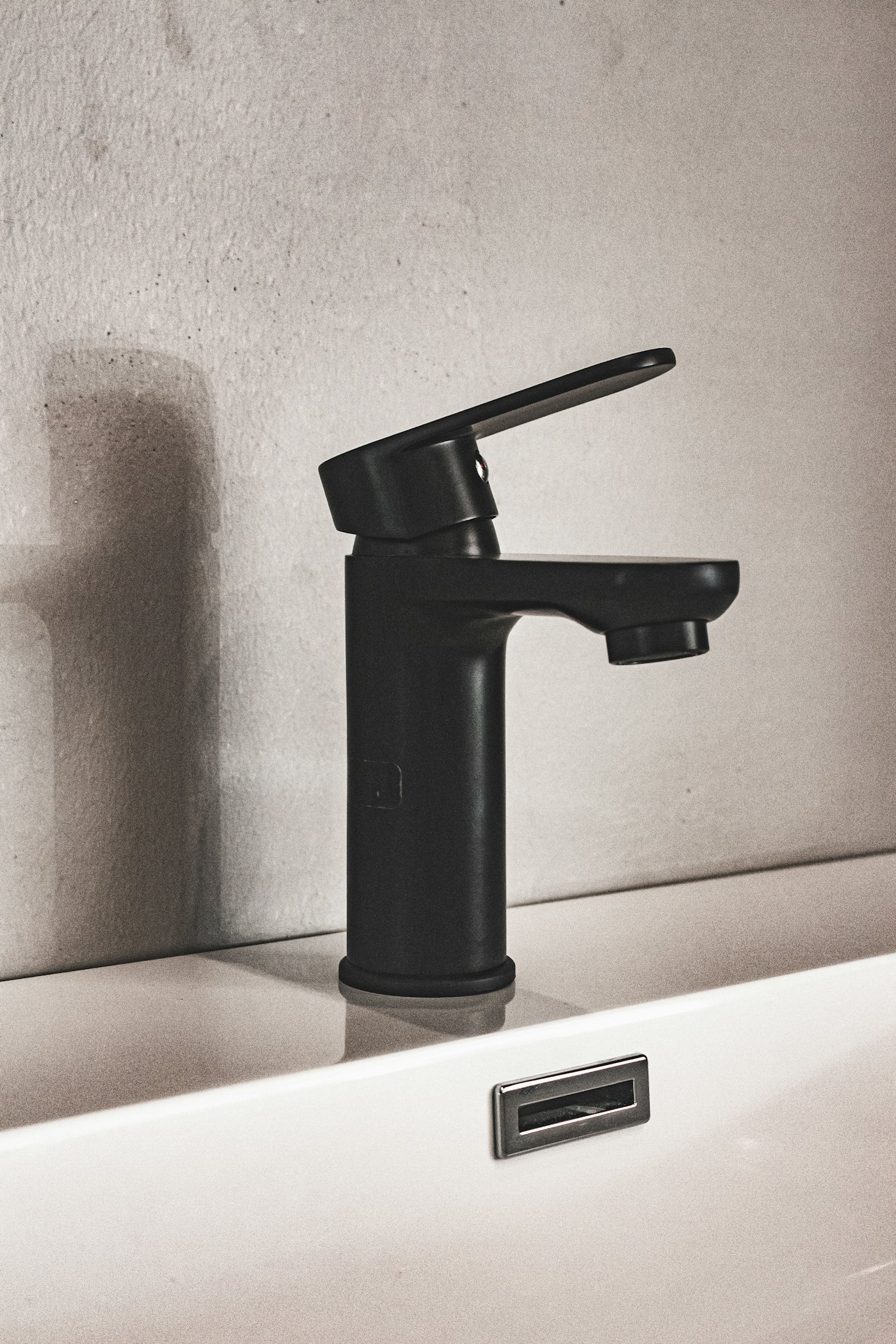 Modern black bathroom faucet installed on a white sink