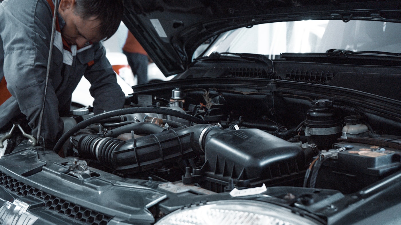 Mechanic working under the hood on drivetrain components