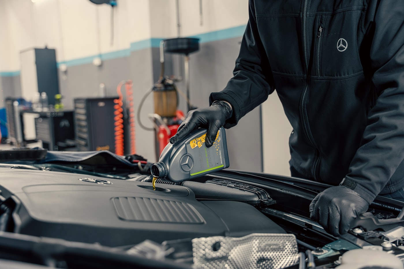 Mechanic pouring fresh oil into a car engine